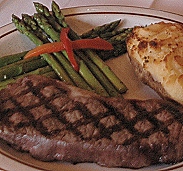 strip steak entree with potato and asparagus spears